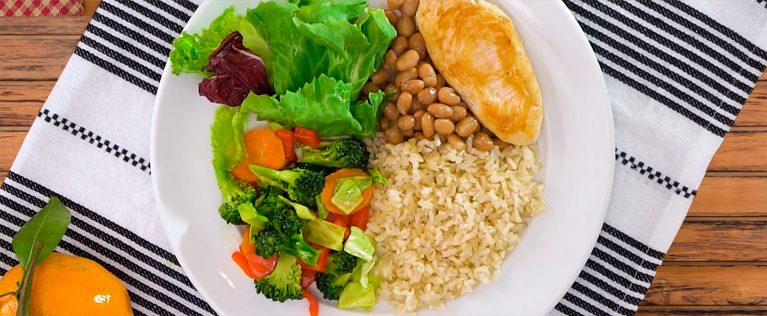 Prato com arroz, feijão, uma carne e uma salada com diversas verduras